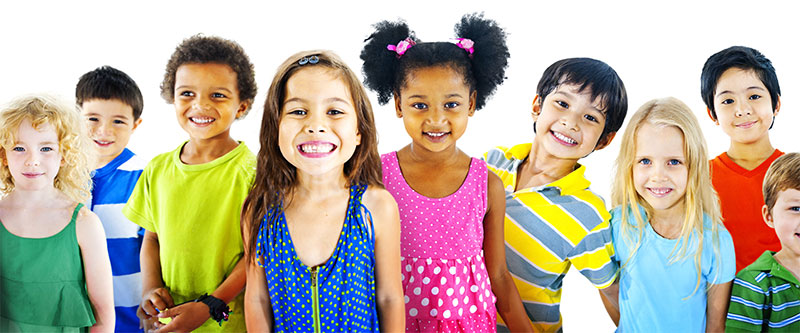 The image features a diverse group of children and young adults posing for a photograph, with a mix of ethnicities and styles of clothing.