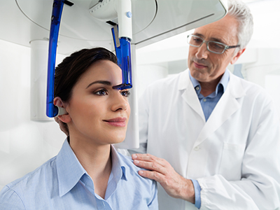 A medical professional assisting a patient with a head scanner in a healthcare setting.