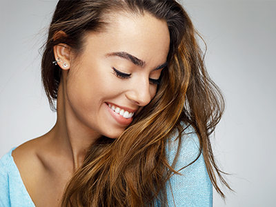 A young woman with long brown hair, smiling gently at the camera.